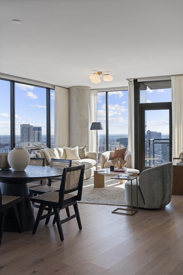 dining room featuring a healthy amount of sunlight, a view of city, and wood finished floors