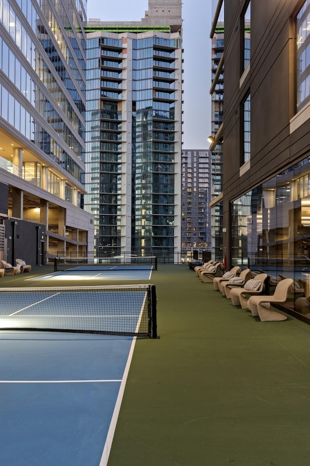 view of tennis court with a city view