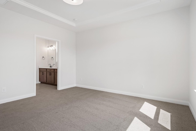 unfurnished bedroom featuring ornamental molding, ensuite bath, carpet flooring, and baseboards