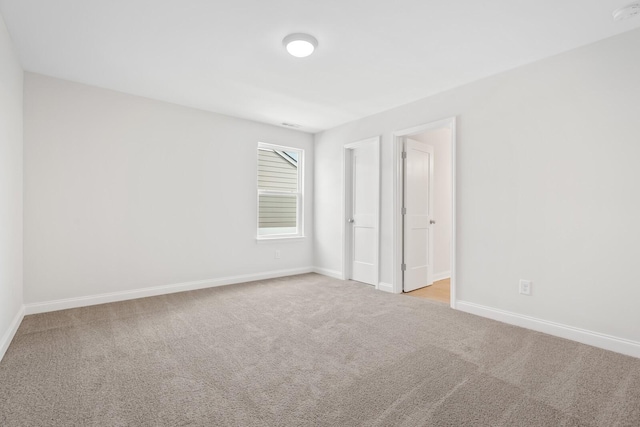 unfurnished bedroom featuring baseboards and light colored carpet