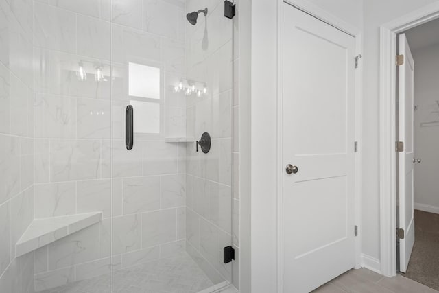 bathroom featuring a shower stall and baseboards