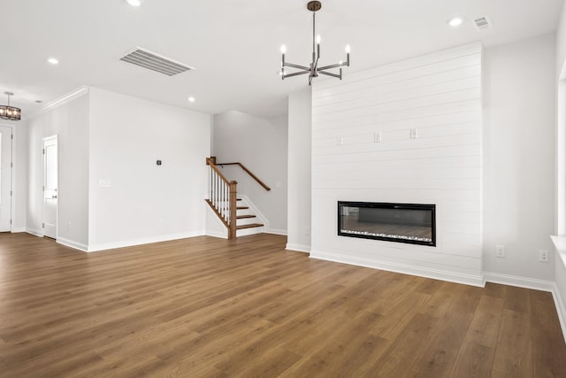 unfurnished living room featuring an inviting chandelier, dark wood-style floors, and visible vents