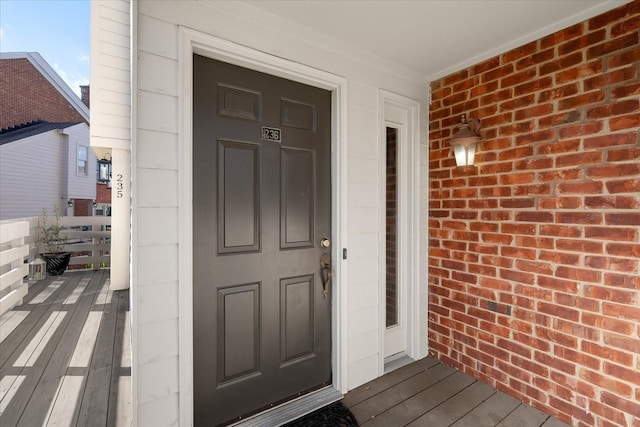 view of exterior entry featuring brick siding