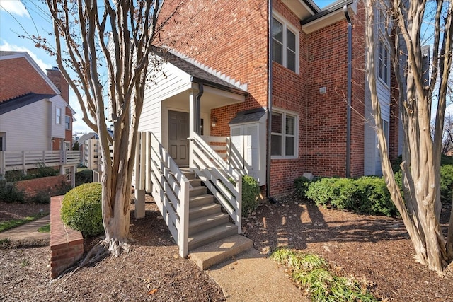 entrance to property with fence and brick siding