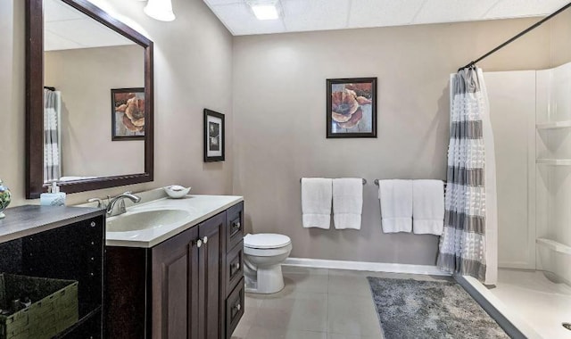 bathroom with a drop ceiling, toilet, a shower with curtain, tile patterned flooring, and vanity