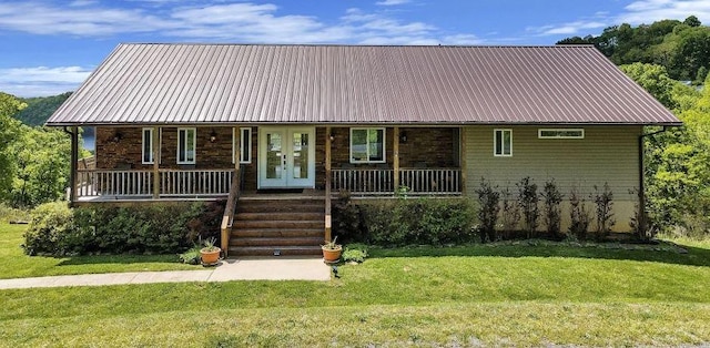 view of front of property featuring metal roof, a front lawn, a porch, and french doors