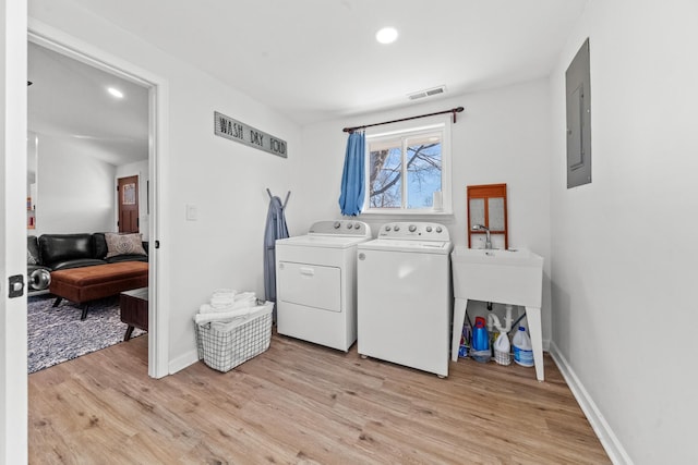 washroom with laundry area, light wood finished floors, electric panel, visible vents, and independent washer and dryer