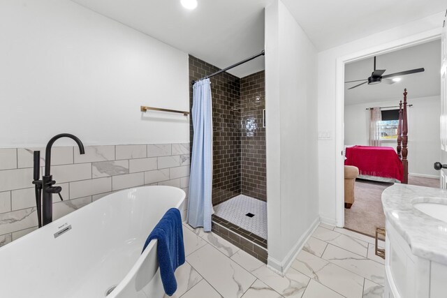 ensuite bathroom featuring marble finish floor, a freestanding bath, a ceiling fan, connected bathroom, and a shower stall