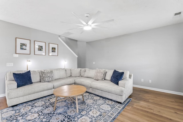 living room featuring baseboards, visible vents, ceiling fan, and wood finished floors