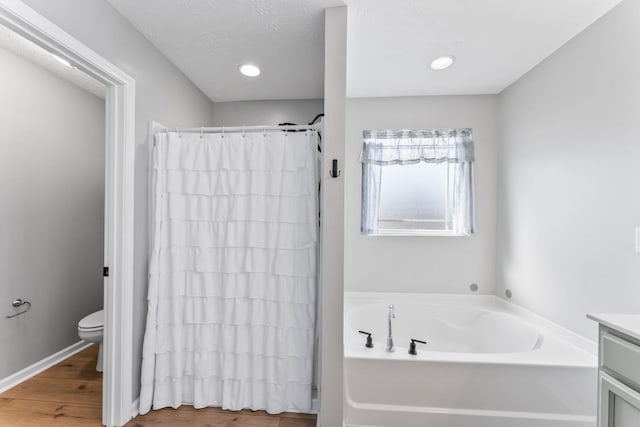 bathroom with a shower with curtain, wood finished floors, toilet, and a bath