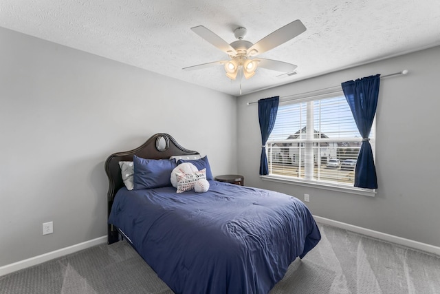 carpeted bedroom featuring a textured ceiling, a ceiling fan, visible vents, and baseboards