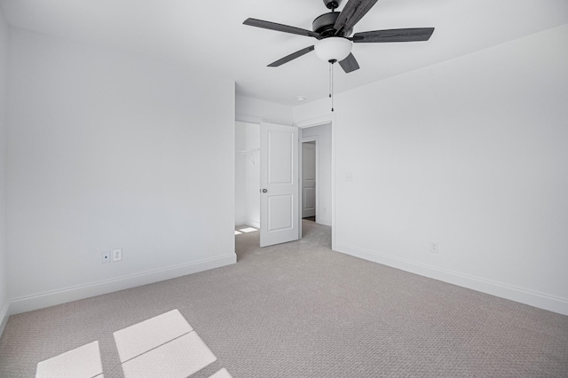 unfurnished bedroom featuring light carpet, a ceiling fan, and baseboards