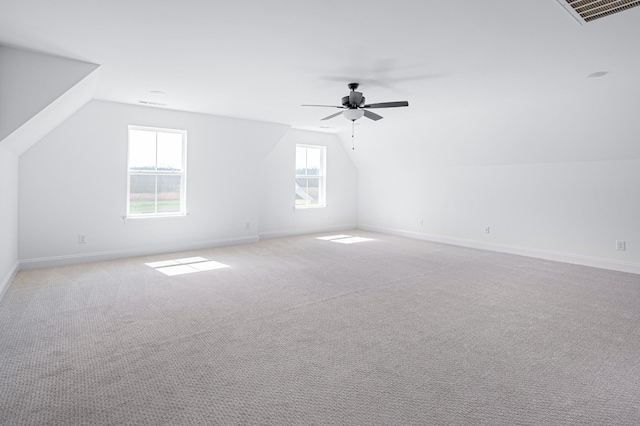 bonus room with light carpet, lofted ceiling, visible vents, and baseboards