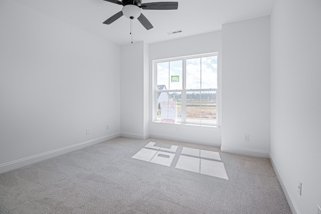 spare room featuring light carpet, baseboards, visible vents, and a ceiling fan