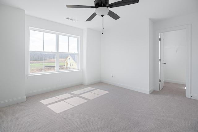 unfurnished room with baseboards, ceiling fan, visible vents, and light colored carpet