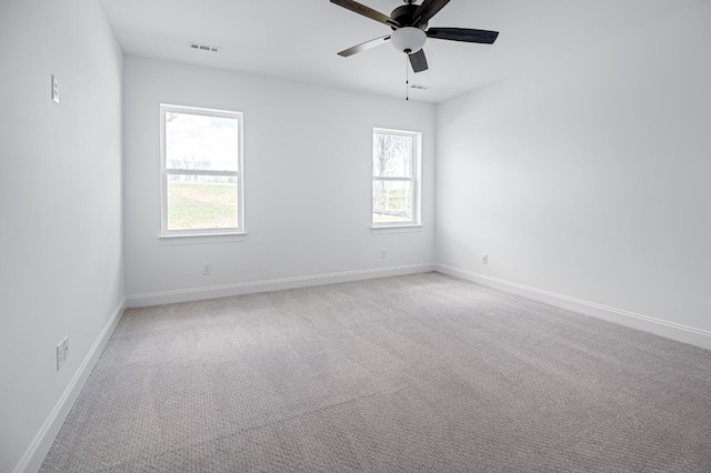 unfurnished room featuring light carpet, visible vents, baseboards, and ceiling fan