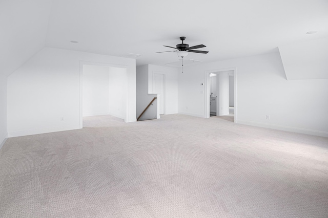 additional living space with lofted ceiling, ceiling fan, baseboards, and light colored carpet