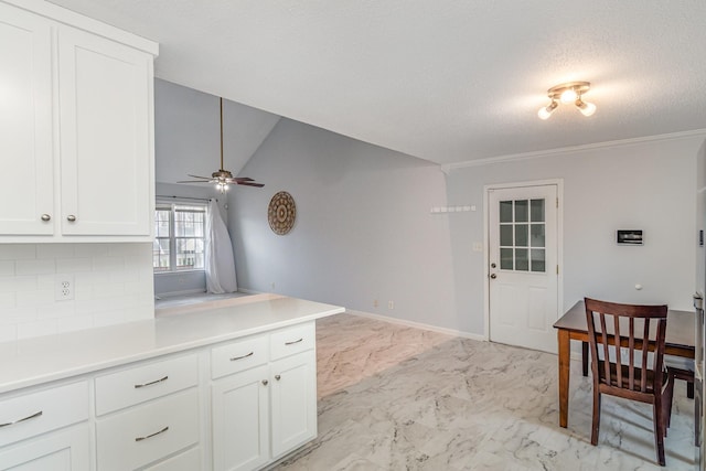 kitchen featuring white cabinets, decorative backsplash, marble finish floor, light countertops, and a textured ceiling