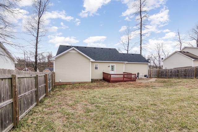 rear view of house with a deck, a shingled roof, a lawn, and a fenced backyard