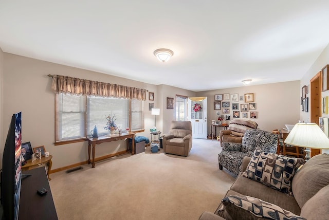 living room featuring carpet, visible vents, and baseboards