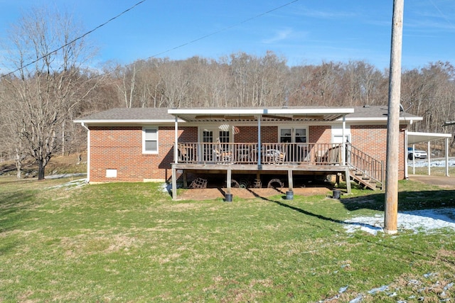 back of property featuring a yard, brick siding, and a wooden deck