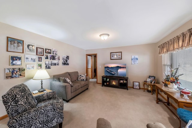 living area featuring baseboards and light colored carpet