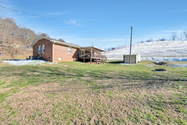 view of yard featuring a shed, an outdoor structure, and a wooden deck