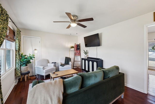 living area featuring dark wood-style floors, ceiling fan, and baseboards