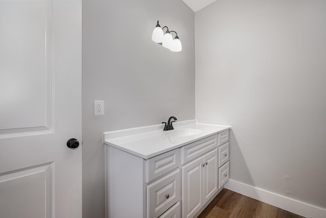 bathroom featuring wood finished floors, vanity, and baseboards