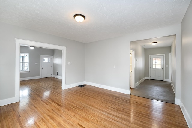 foyer entrance featuring baseboards, visible vents, plenty of natural light, and light wood finished floors