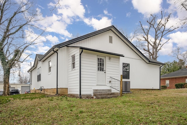 rear view of house featuring a yard and central AC unit