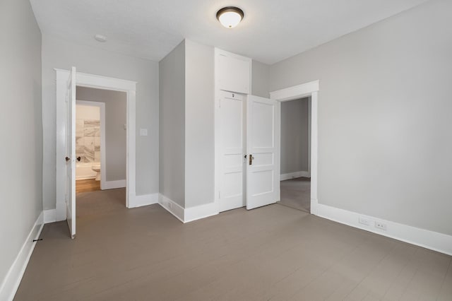 unfurnished bedroom featuring a closet, baseboards, and wood finished floors