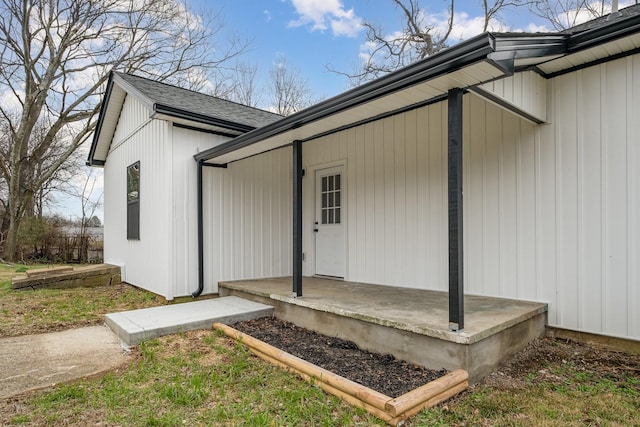 doorway to property with roof with shingles