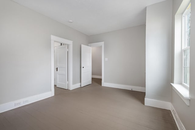 unfurnished bedroom featuring wood finished floors and baseboards