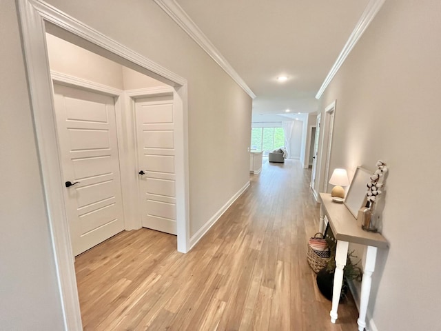 corridor featuring light wood finished floors, ornamental molding, recessed lighting, and baseboards