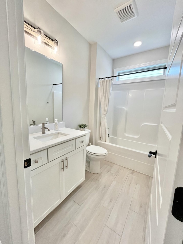 full bathroom featuring visible vents, toilet, vanity, shower / tub combo with curtain, and wood finish floors