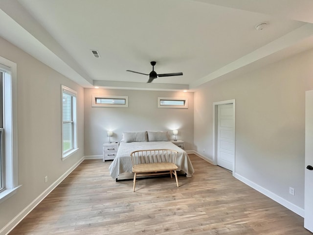 bedroom with light wood-style floors, baseboards, visible vents, and ceiling fan