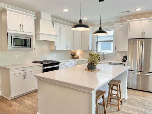 kitchen with stainless steel appliances, white cabinets, light countertops, and custom exhaust hood