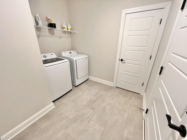 washroom featuring laundry area, baseboards, and separate washer and dryer