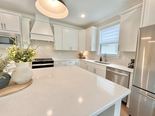 kitchen featuring white cabinets, custom exhaust hood, stainless steel appliances, and a sink