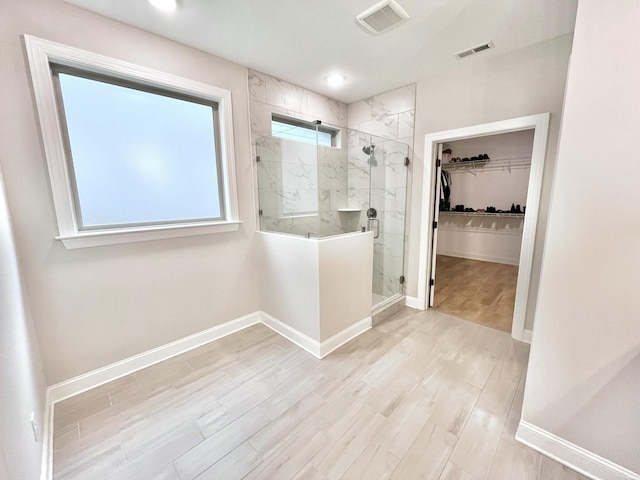 full bath with visible vents, a spacious closet, baseboards, and wood finished floors