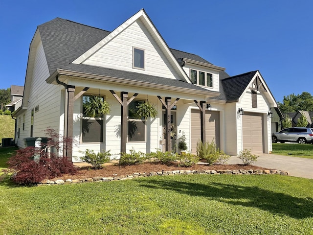 view of front of property with concrete driveway, roof with shingles, an attached garage, covered porch, and a front yard