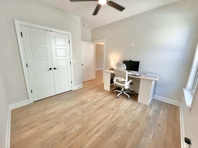 office space with light wood-style floors, ceiling fan, and baseboards