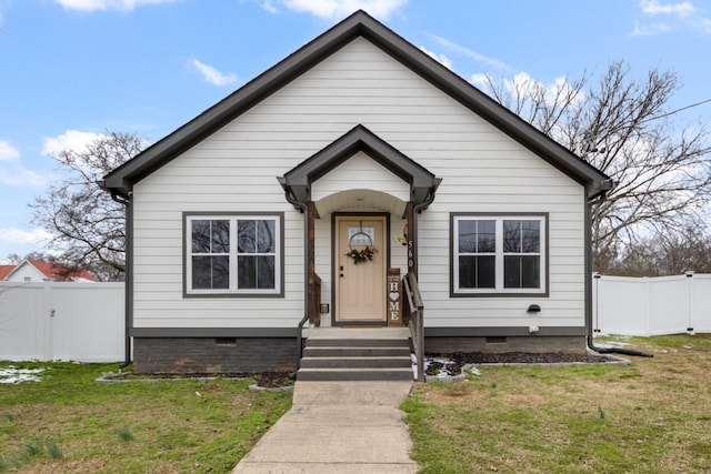 bungalow-style home featuring a front yard, crawl space, and fence