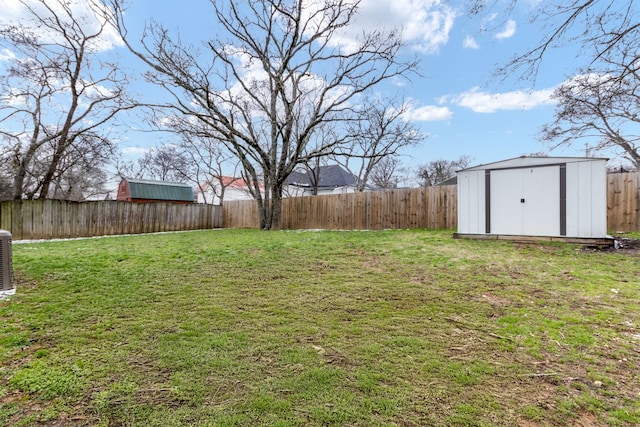 view of yard featuring an outbuilding, a storage unit, and a fenced backyard