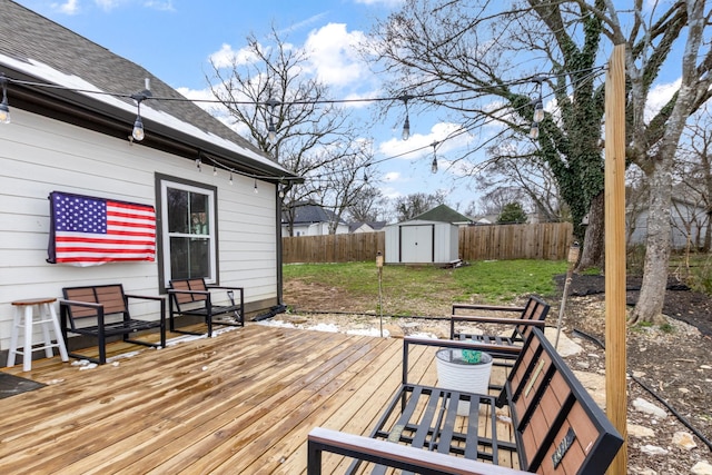 wooden terrace with a yard, a fenced backyard, a storage unit, and an outbuilding