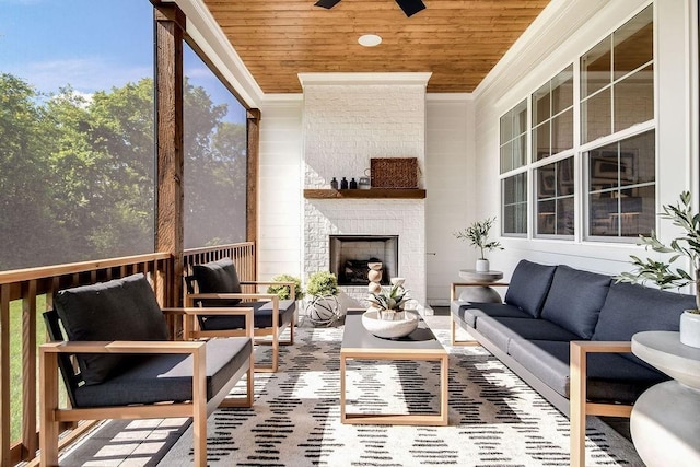 sunroom with a brick fireplace, wood ceiling, and a ceiling fan