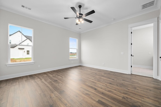 empty room with ornamental molding, dark wood finished floors, visible vents, and baseboards