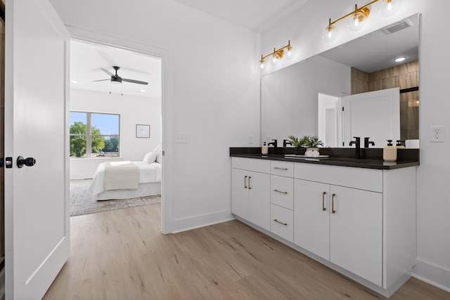 bathroom featuring double vanity, baseboards, visible vents, ensuite bath, and wood finished floors