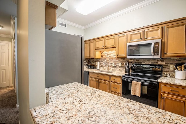 kitchen with light stone counters, visible vents, a sink, and black appliances